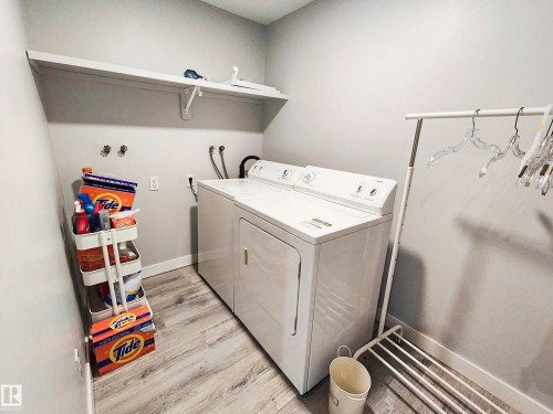 Dedicated laundry area featuring a shelf, light gray walls, and wood-look flooring - 215 Peter Close Nw, Edmonton, AB - Indoor Photo Showing Laundry Room