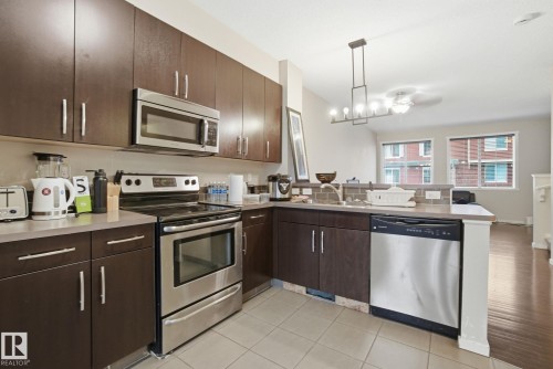 The kitchen features stainless steel appliances, including a microwave, oven, and dishwasher - 75 603 Watt Boulevard, Edmonton, AB - Indoor Photo Showing Kitchen