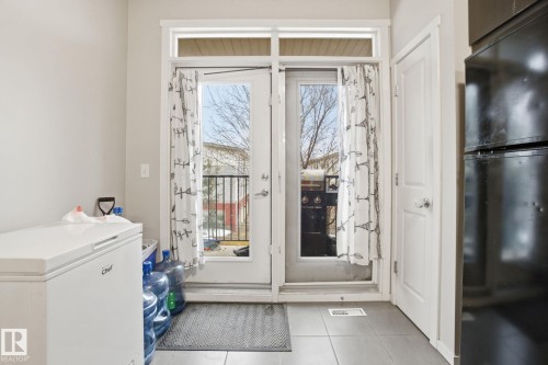 Entryway featuring tiled flooring and a white door with a clear glass window, providing access to an outdoor area - 75 603 Watt Boulevard, Edmonton, AB - Indoor