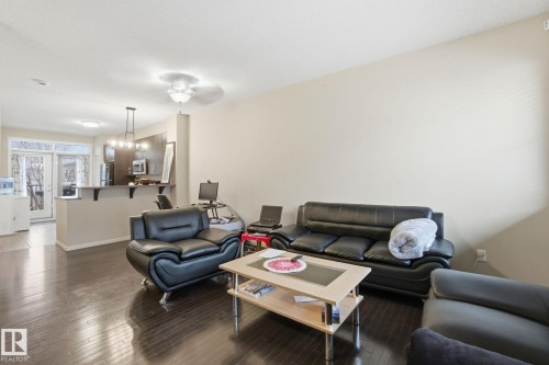 Living area featuring dark hardwood floors, light-colored walls, and a ceiling light fixture - 75 603 Watt Boulevard, Edmonton, AB - Indoor Photo Showing Living Room