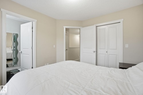 This inviting bedroom features light-colored walls and a textured ceiling - 75 603 Watt Boulevard, Edmonton, AB - Indoor Photo Showing Bedroom