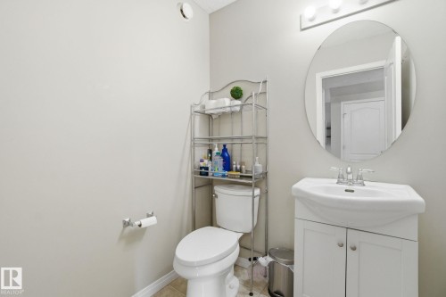 Bathroom with a white vanity and sink, a mirror, and a toilet - 3026 16A Avenue, Edmonton, AB - Indoor Photo Showing Bathroom