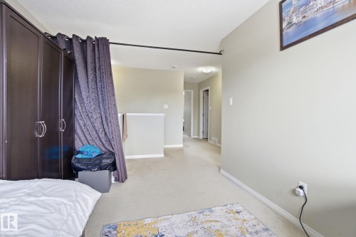 The property features a spacious room with carpeting and light-colored walls, providing a neutral backdrop - 3026 16A Avenue, Edmonton, AB - Indoor Photo Showing Bedroom
