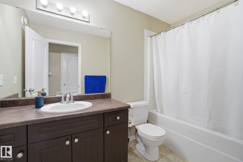 Bathroom with a dark wood vanity, white sink, and a combination shower and bathtub - 3026 16A Avenue, Edmonton, AB - Indoor Photo Showing Bathroom