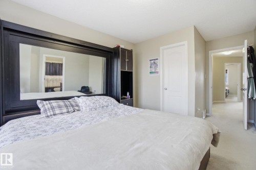 This room features light-colored walls and carpeting, with white doors and trim, creating a bright atmosphere - 3026 16A Avenue, Edmonton, AB - Indoor Photo Showing Bedroom