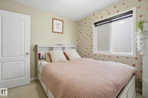 Bedroom featuring a window with blinds, light-colored walls, and a white door with a silver knob - 3026 16A Avenue, Edmonton, AB - Indoor Photo Showing Bedroom
