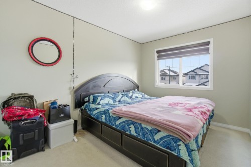 This room features light-colored walls and carpeting, a window with blinds, and a ceiling light fixture - 3026 16A Avenue, Edmonton, AB - Indoor Photo Showing Bedroom