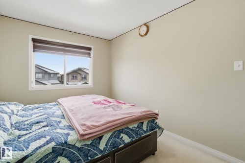 The property features a room with a large window, providing natural light, and neutral-toned walls - 3026 16A Avenue, Edmonton, AB - Indoor Photo Showing Bedroom