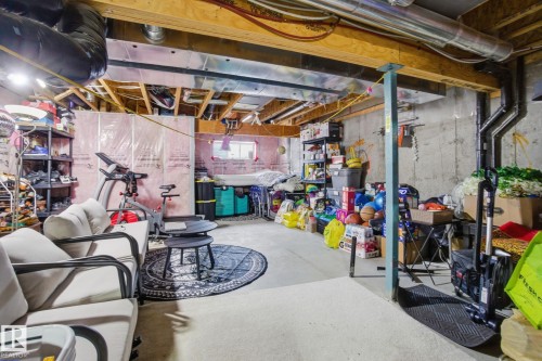 The property features an unfinished basement with exposed wooden beams, concrete walls, and visible ductwork - 3026 16A Avenue, Edmonton, AB - Indoor Photo Showing Basement