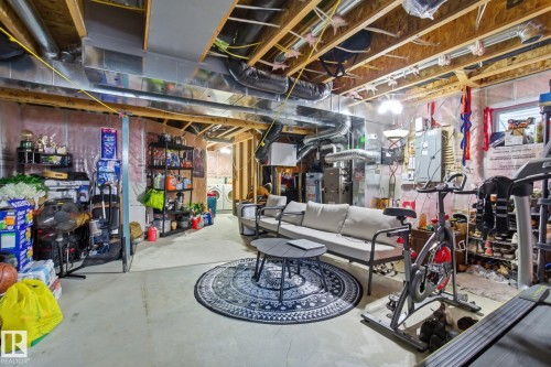The property features an unfinished basement with exposed ceiling joists and ductwork, providing a versatile space - 3026 16A Avenue, Edmonton, AB - Indoor Photo Showing Basement