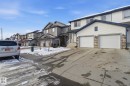 The property features a two-car garage with white doors and stone detailing - 3026 16A Avenue, Edmonton, AB  - Outdoor With Facade 
