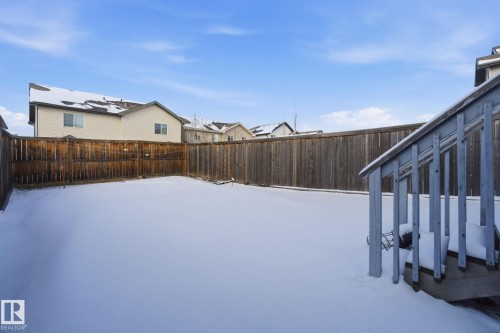 The property features a spacious yard with a wooden fence and a deck with railings - 3026 16A Avenue, Edmonton, AB - Outdoor