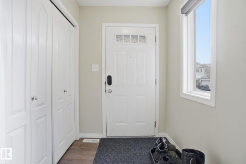 Entryway featuring a white door with transom windows, a window providing natural light, and bifold closet doors - 3026 16A Avenue, Edmonton, AB - Indoor Photo Showing Other Room