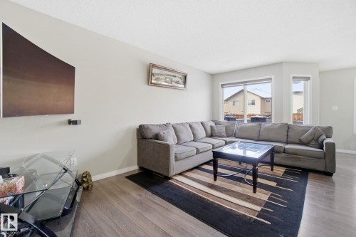 Living room with durable wood-style flooring, light-colored walls, and large windows providing ample natural light - 3026 16A Avenue, Edmonton, AB - Indoor Photo Showing Living Room