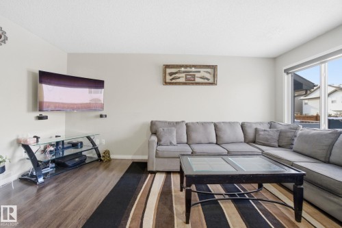 Living area featuring wood-look flooring, a large window, and light-colored walls - 3026 16A Avenue, Edmonton, AB - Indoor Photo Showing Living Room