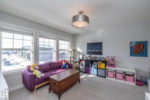 This room features three large windows that provide abundant natural light - 26 Ellice Bend, Fort Saskatchewan, AB - Indoor Photo Showing Living Room