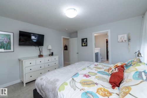This bedroom features light gray walls, a ceiling-mounted light fixture, and carpeted flooring - 26 Ellice Bend, Fort Saskatchewan, AB - Indoor Photo Showing Bedroom
