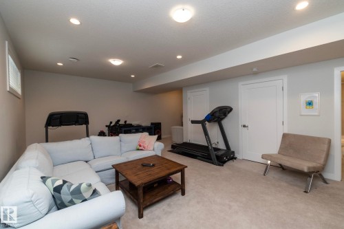 The property features a spacious living area with recessed lighting and neutral-toned carpeting, providing a versatile space for various uses - 26 Ellice Bend, Fort Saskatchewan, AB - Indoor Photo Showing Basement