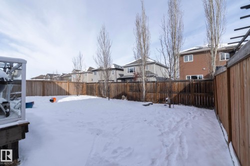 The property features a fenced backyard with a snow-covered lawn and a wooden deck - 26 Ellice Bend, Fort Saskatchewan, AB - Outdoor
