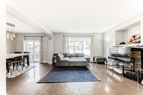 Open-concept living area with hardwood floors, a built-in media niche, and a glass sliding door leading to a deck - 16720 61 Street, Edmonton, AB - Indoor Photo Showing Living Room