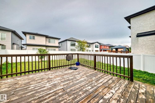 The property features a spacious deck with a wooden surface and a railing, overlooking a fenced yard with a lawn - 16720 61 Street, Edmonton, AB - Outdoor With Deck Patio Veranda With Exterior