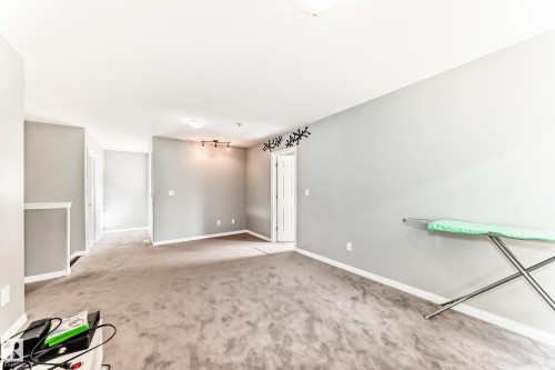 The property features neutral-toned carpet flooring and light grey walls, creating a versatile interior - 16720 61 Street, Edmonton, AB - Indoor Photo Showing Other Room