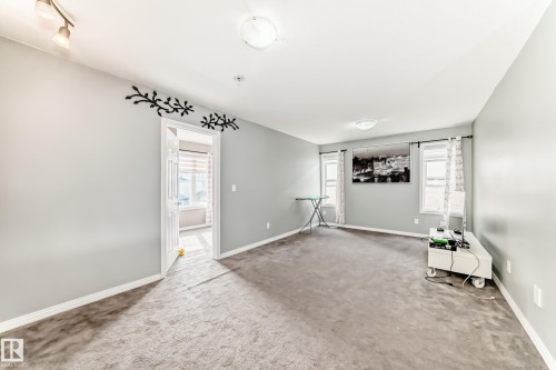 This inviting living space features carpeting, light grey walls, and two windows allowing for natural light - 16720 61 Street, Edmonton, AB - Indoor Photo Showing Other Room