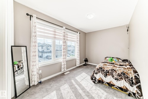 This room features light gray carpeting, neutral wall paint, and white trim - 16720 61 Street, Edmonton, AB - Indoor Photo Showing Bedroom