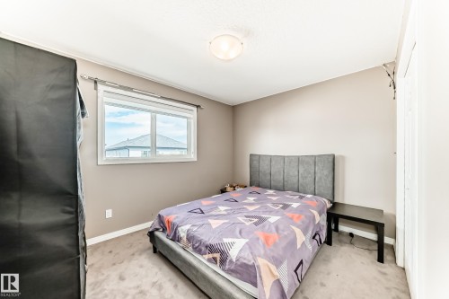This room features neutral-toned walls, a window providing natural light, and light-colored carpeting - 16720 61 Street, Edmonton, AB - Indoor Photo Showing Bedroom