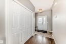 The entryway features a front door with decorative glass inserts, a ceiling light fixture, and a combination of wood-look and tiled flooring - 16720 61 Street, Edmonton, AB  - Indoor Photo Showing Other Room 