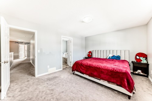 This bedroom features light gray walls, light-colored carpeting, and a white ceiling with a flush-mount light fixture - 16720 61 Street, Edmonton, AB - Indoor Photo Showing Bedroom