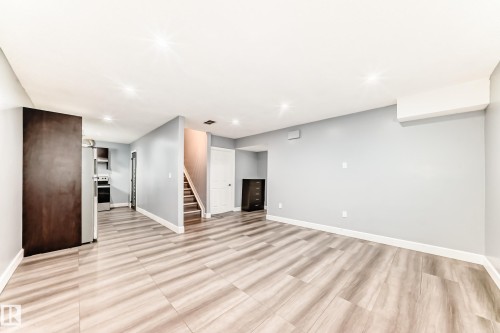 Spacious room featuring light grey walls, light-toned wood-style flooring, and recessed lighting - 16720 61 Street, Edmonton, AB - Indoor