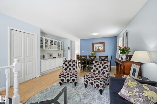 This open concept space features light wood flooring and a built-in display cabinet with glass doors - 85 Arlington Drive, St. Albert, AB - Indoor