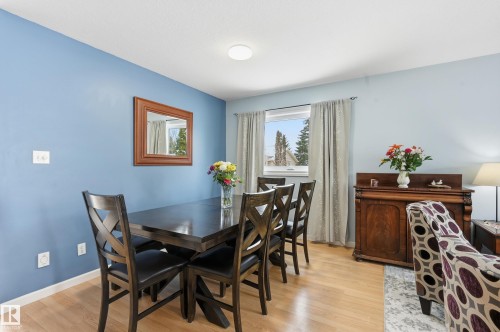 Dining area featuring hardwood style flooring, a window with curtains, and light blue walls - 85 Arlington Drive, St. Albert, AB - Indoor Photo Showing Dining Room