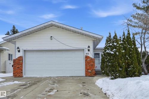 The property features a white exterior with brick accents, a garage, and an inviting front entrance - 85 Arlington Drive, St. Albert, AB - Outdoor