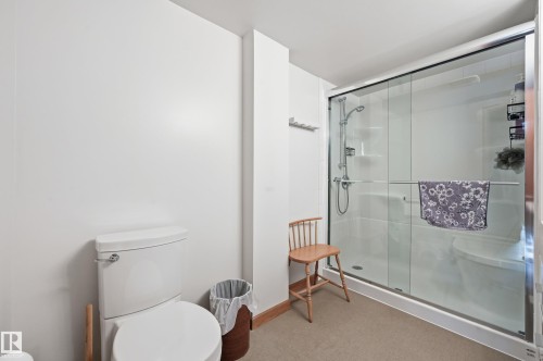 The bathroom features a toilet and a shower enclosure with clear glass doors - 85 Arlington Drive, St. Albert, AB - Indoor Photo Showing Bathroom