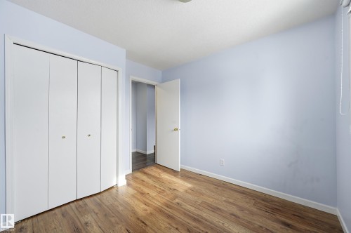 This room features light blue walls, hardwood flooring, and a closet with bi-fold doors - 85 Arlington Drive, St. Albert, AB - Indoor Photo Showing Other Room