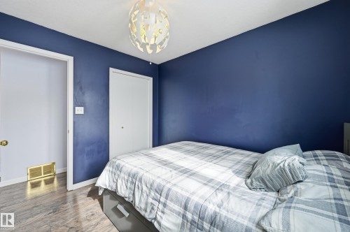 This room features dark blue walls, light colored flooring, and a modern ceiling light fixture - 85 Arlington Drive, St. Albert, AB - Indoor Photo Showing Bedroom