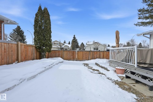 The property features a fenced yard with a deck and steps, and a large evergreen tree - 85 Arlington Drive, St. Albert, AB - Outdoor