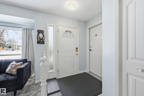 Entryway featuring light blue walls, two white panel doors, and a window with a view of the outdoors - 85 Arlington Drive, St. Albert, AB - Indoor Photo Showing Other Room