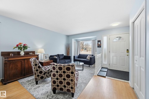 Inviting living space featuring light blue walls, hardwood flooring, and a large front window providing natural light - 85 Arlington Drive, St. Albert, AB - Indoor Photo Showing Living Room