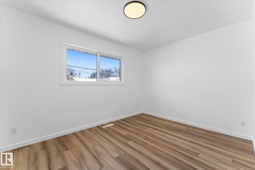 This interior room features white walls, a window with a white frame, and a ceiling light fixture - 13116 128A Avenue, Edmonton, AB - Indoor Photo Showing Other Room