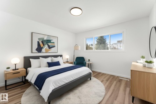 This bright room features a large window, light-toned flooring, and a ceiling-mounted light fixture - 13116 128A Avenue, Edmonton, AB - Indoor Photo Showing Bedroom