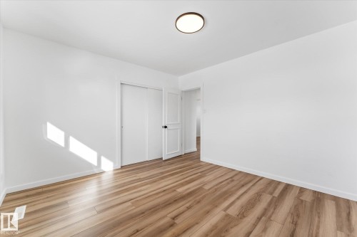 This room features light wood-look flooring, white walls, and a ceiling-mounted light fixture - 13116 128A Avenue, Edmonton, AB - Indoor Photo Showing Other Room