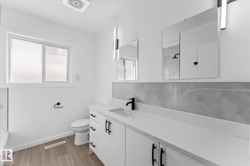 Bathroom featuring a white vanity with black hardware, a light-colored countertop, and a rectangular sink with a black faucet - 13116 128A Avenue, Edmonton, AB - Indoor Photo Showing Bathroom