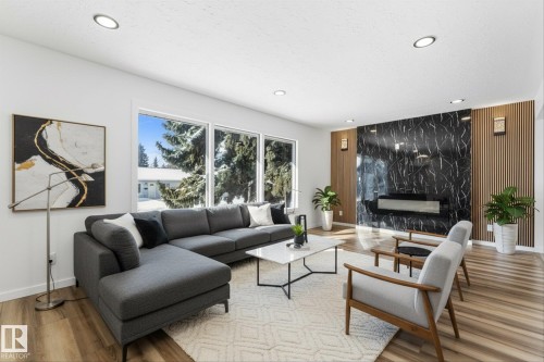 The living area features large windows, recessed lighting, and wood-style flooring - 13116 128A Avenue, Edmonton, AB - Indoor Photo Showing Living Room