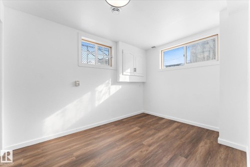 Room with wood-style flooring, white walls, and two windows providing natural light - 13116 128A Avenue, Edmonton, AB - Indoor Photo Showing Other Room
