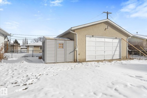 The property includes a detached garage with a white overhead door and an exterior shed - 13116 128A Avenue, Edmonton, AB - Outdoor With Exterior