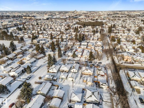 Expansive aerial view showcasing the snow-covered neighborhood, featuring numerous residential properties with visible rooftops and surrounding trees - 13116 128A Avenue, Edmonton, AB - Outdoor With View