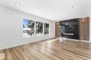 Living area featuring light wood flooring, recessed lighting, and a modern fireplace with a dark marble-patterned surround - 13116 128A Avenue, Edmonton, AB  - Indoor 